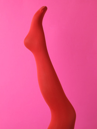 Photo of Leg mannequin in red tights on pink background