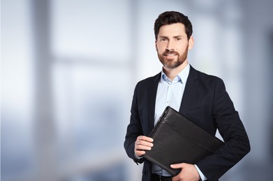 Image of Handsome real estate agent with leather portfolio in office, space for text