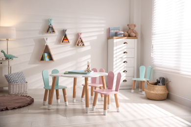 Small table and chairs with bunny ears in children's room interior