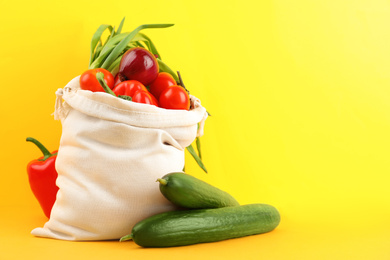 Cotton eco bag with vegetables on yellow background. Space for text