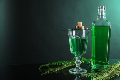 Photo of Absinthe, brown sugar and green leaves on mirror table, space for text. Alcoholic drink