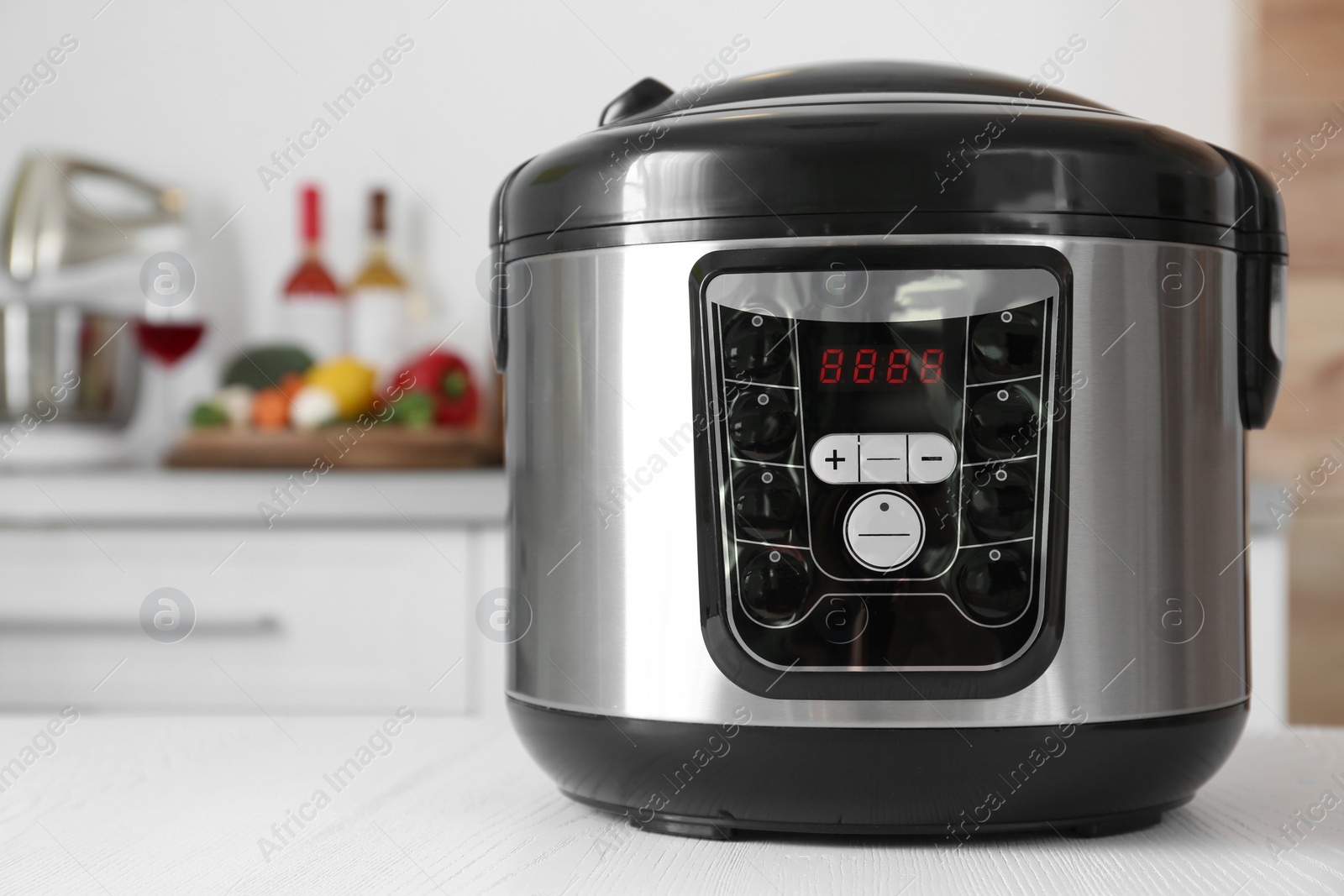 Photo of Modern multi cooker on table in kitchen. Space for text