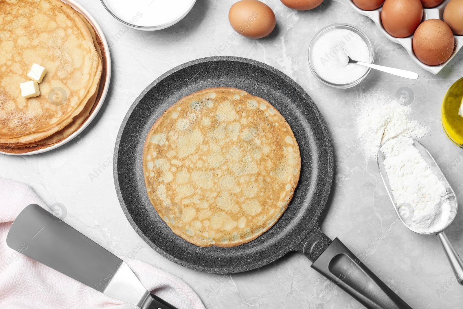 Photo of Flat lay composition with thin pancakes on grey marble table