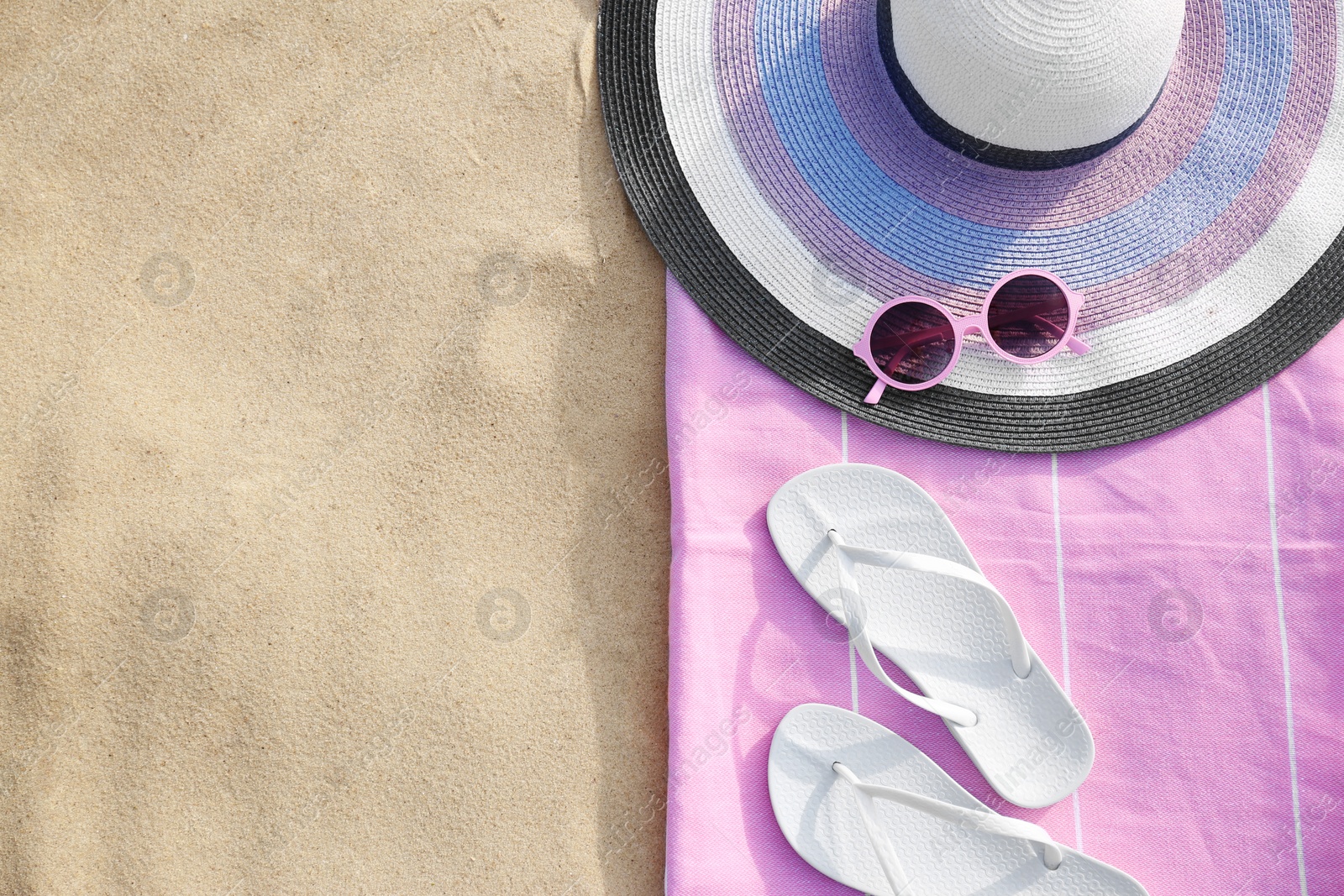 Photo of Flat lay composition of beach objects and towel on sand, space for text