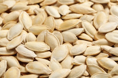 Photo of Many pumpkin seeds as background, closeup view