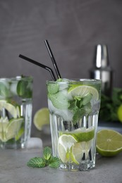 Photo of Glass of fresh Mojito cocktail on grey table, closeup