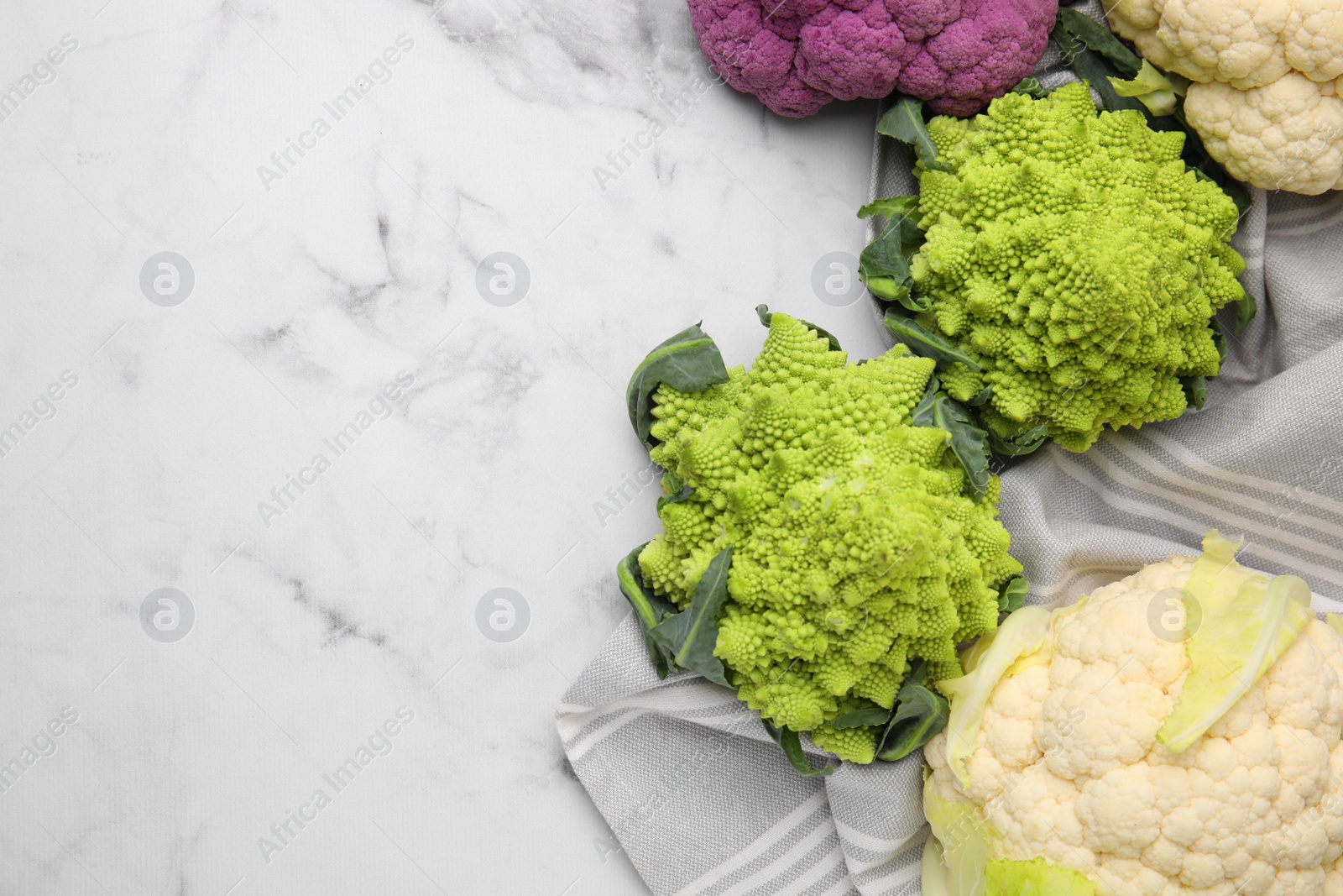 Photo of Different fresh cabbages on white marble table, flat lay. Space for text