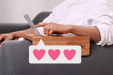 Long distance love. Man sending or receiving text message on sofa, closeup. Speech bubble with hearts near device