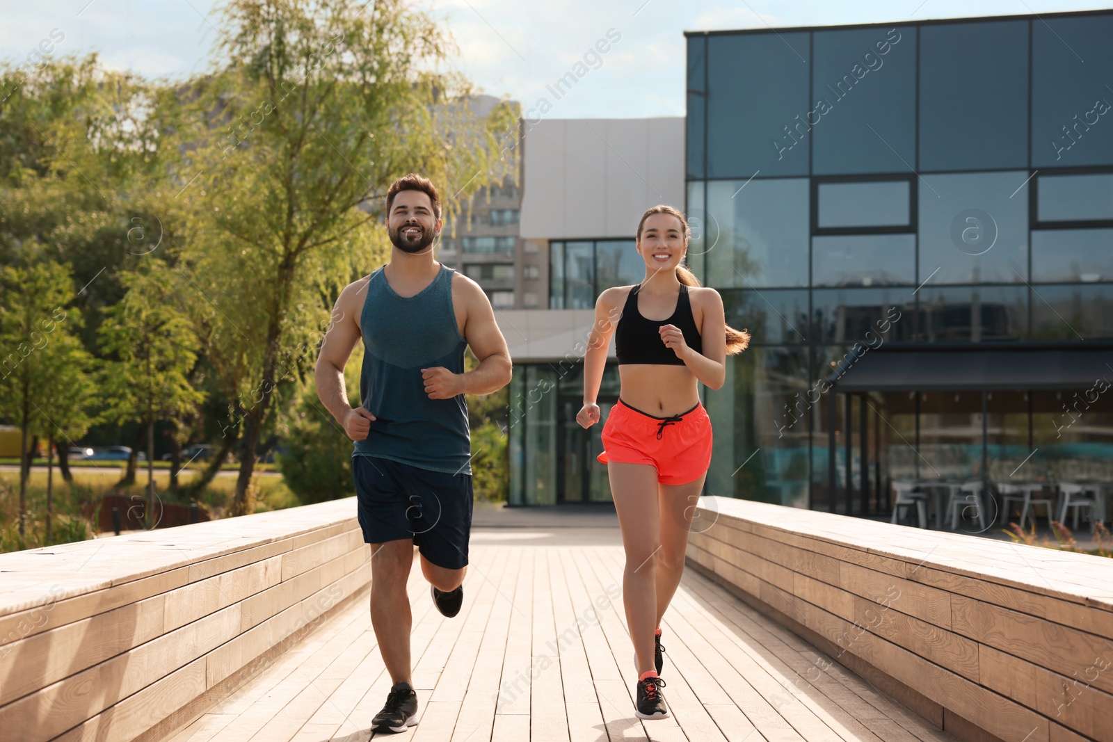 Photo of Healthy lifestyle. Happy couple running outdoors on sunny day