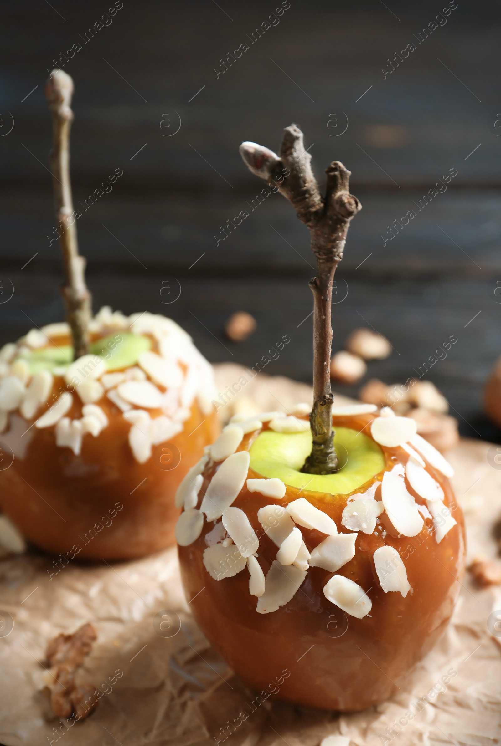 Photo of Delicious caramel apples on wooden background