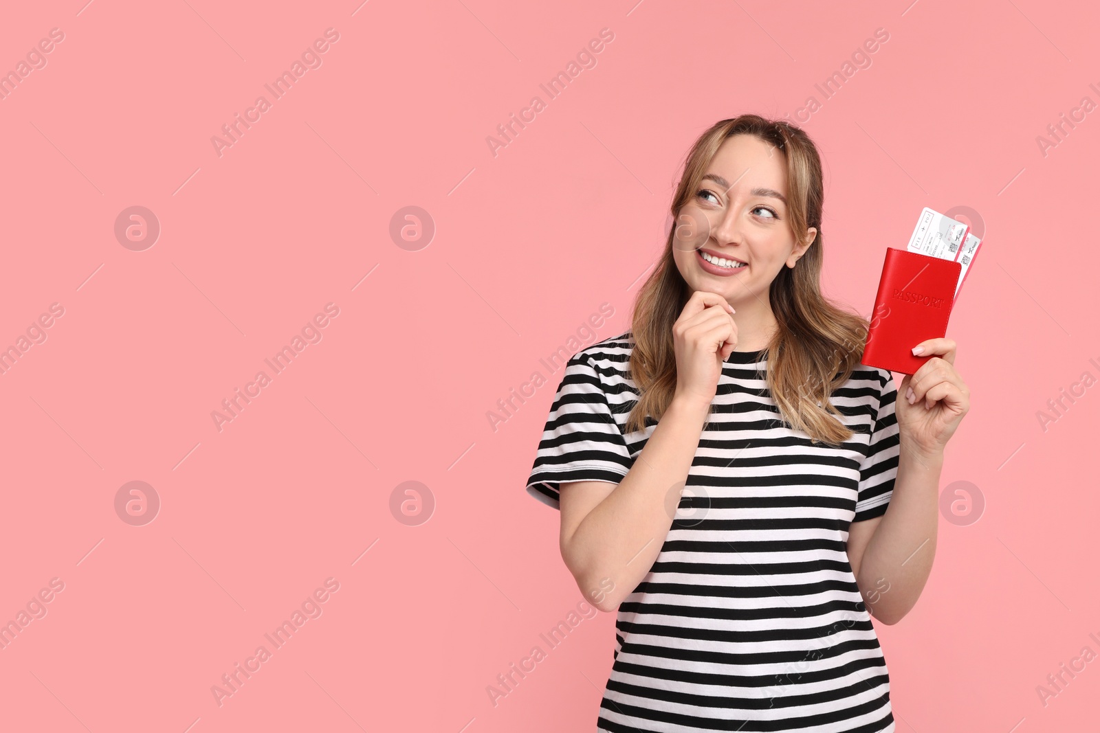 Photo of Happy young woman with passport and ticket on pink background, space for text