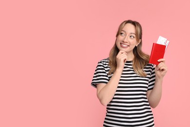 Happy young woman with passport and ticket on pink background, space for text