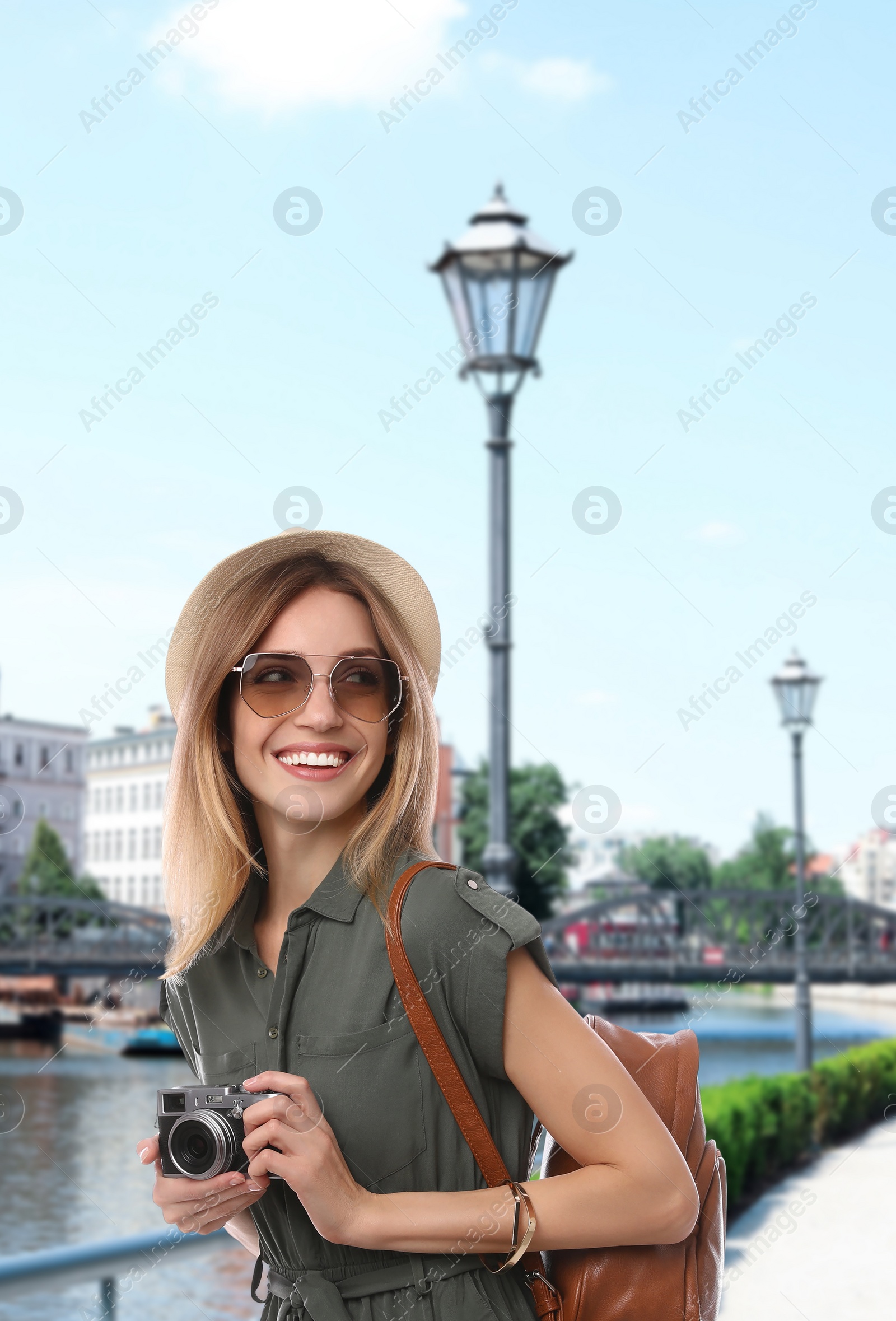 Image of Happy traveler with backpack and camera in foreign city during summer vacation