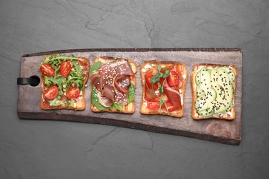 Photo of Different tasty sandwiches on black table, top view