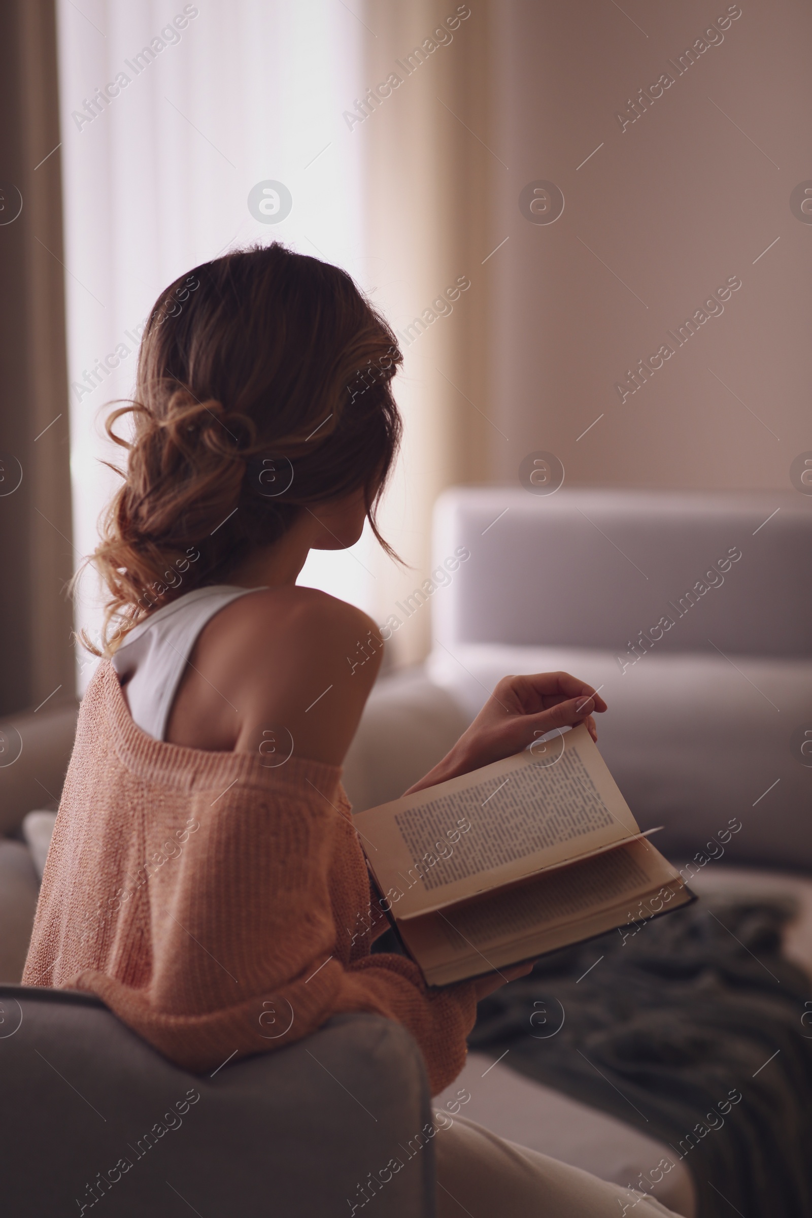 Photo of Beautiful young woman with book relaxing at home. Cozy atmosphere