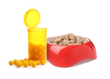 Image of Wet pet food in feeding bowl and vitamin pills on white background