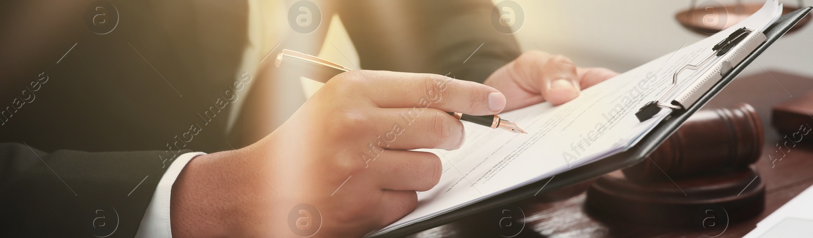 Image of Law and justice. Man working with documents at wooden table, closeup. Banner design