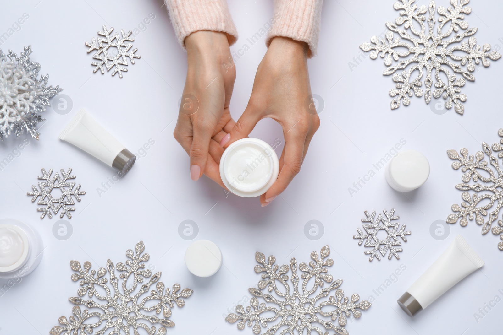 Photo of Woman with jar of hand cream on white background, top view