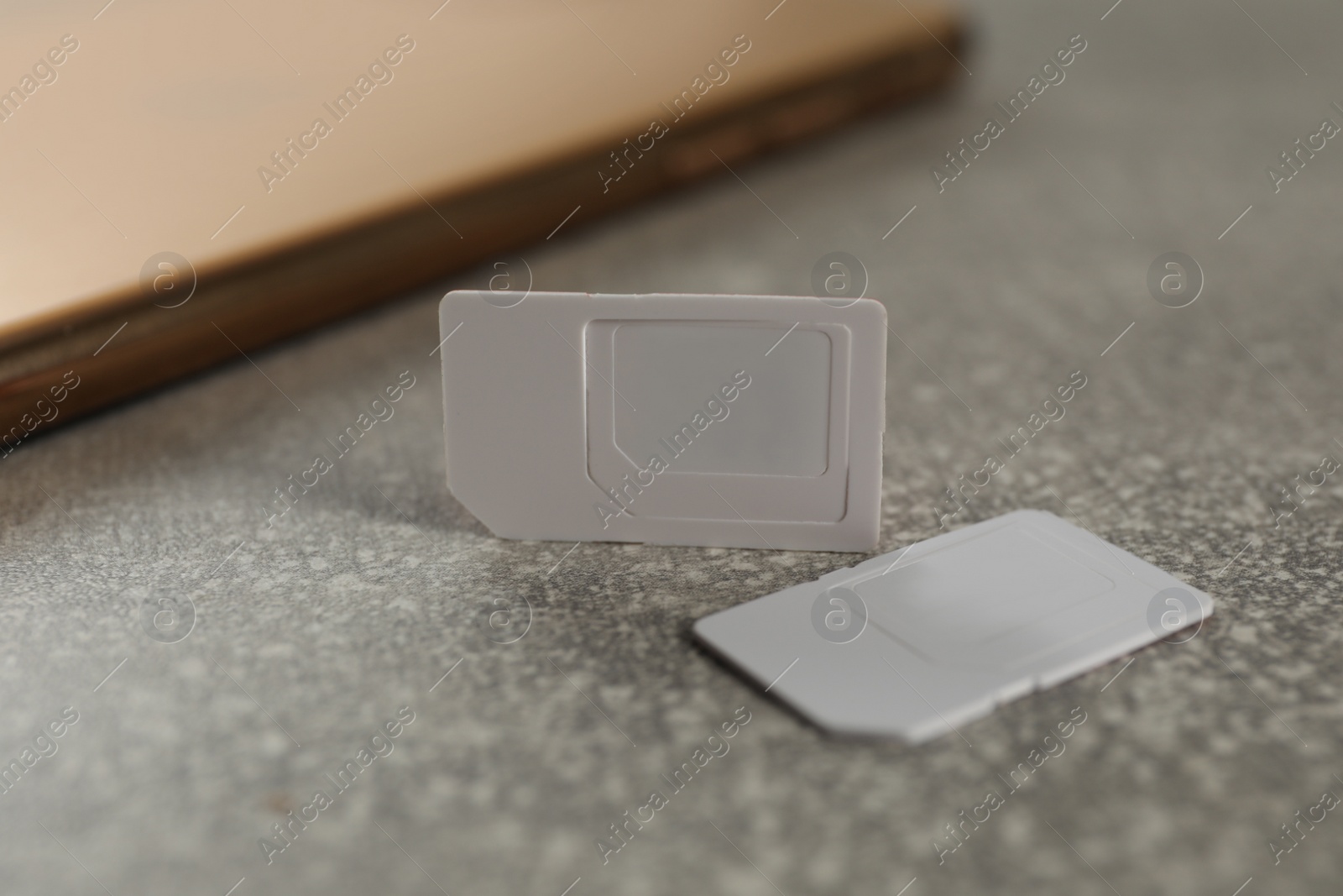 Photo of White multi SIM cards on grey table, closeup