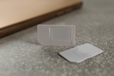 White multi SIM cards on grey table, closeup