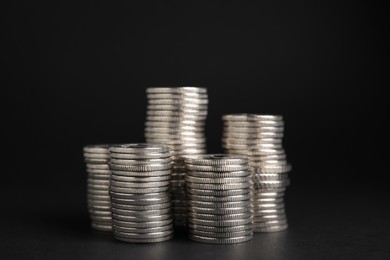 Many Euro coins stacked on black background