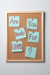 Photo of Cork board with question Are You Ready For Exams made of sticky notes on light grey wall