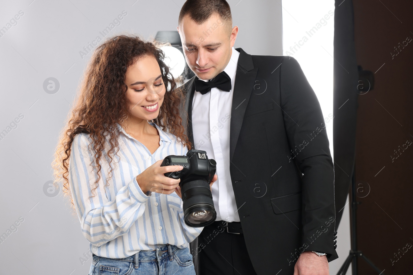 Photo of Handsome model with professional photographer in studio