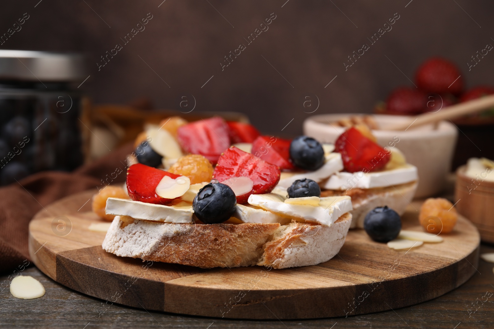 Photo of Tasty brie cheese sandwiches served on wooden table, closeup