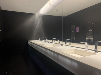 Photo of WARSAW, POLAND - JULY 23, 2022: Restroom interior with mirror and sinks in shopping mall