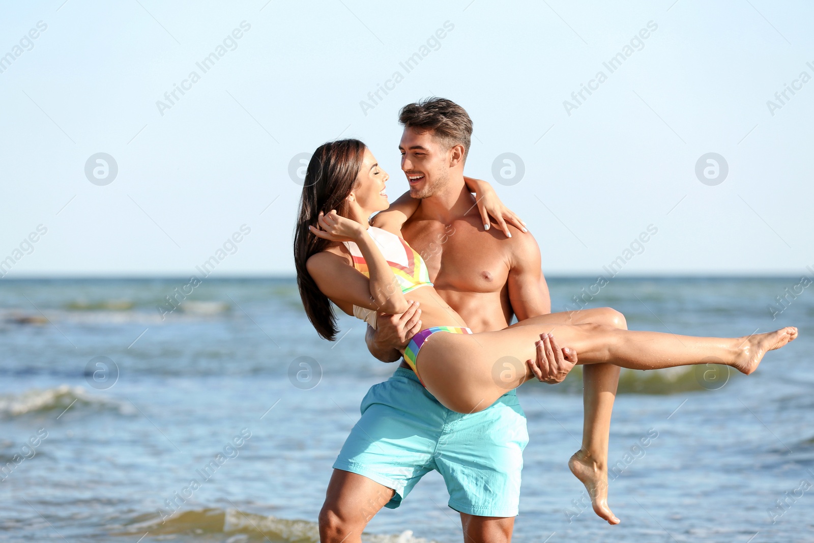 Photo of Happy young couple having fun at beach on sunny day