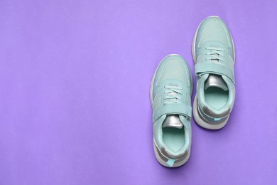 Photo of Pair of comfortable sports shoes on violet background, flat lay. Space for text