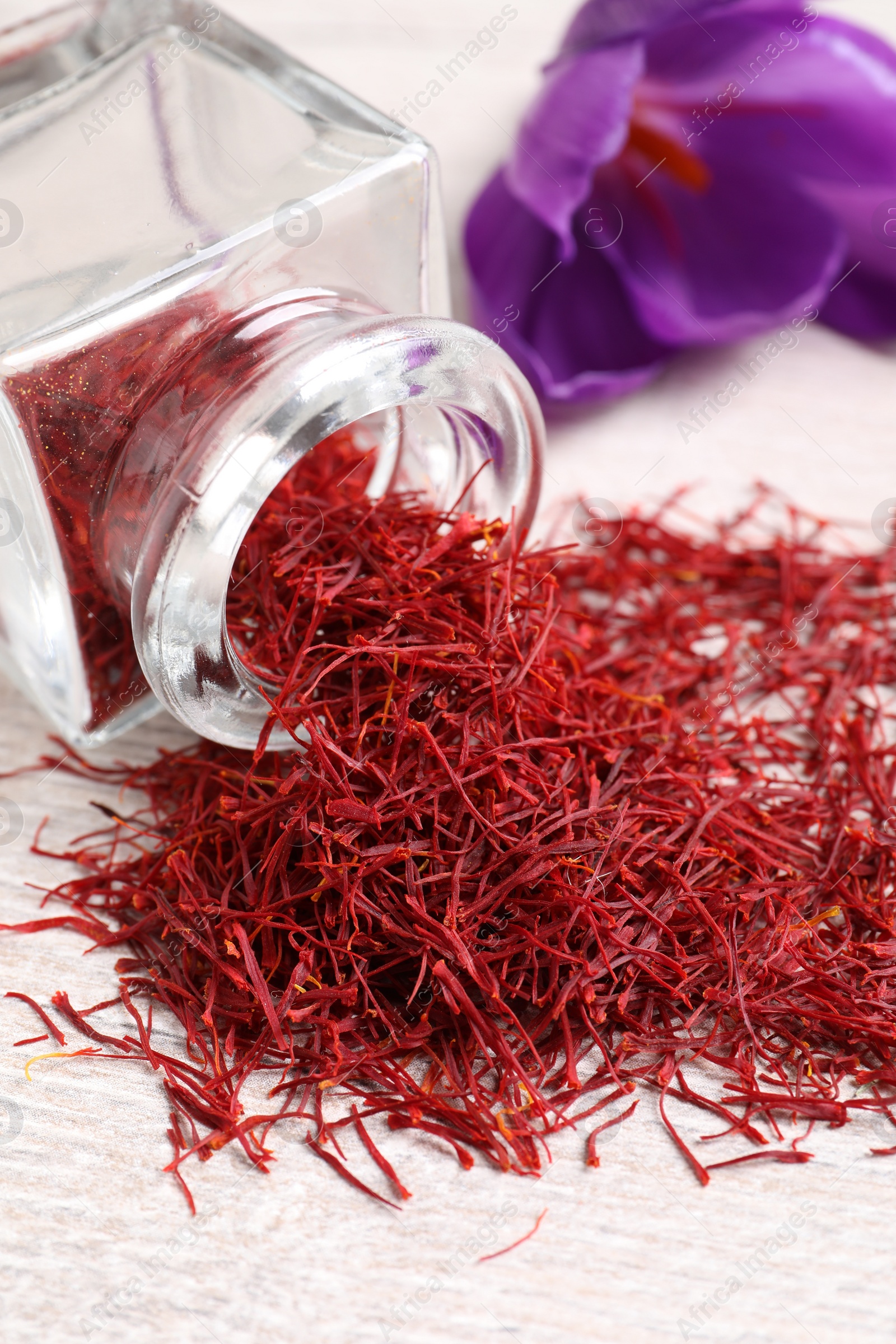 Photo of Dried saffron and crocus flower on white wooden table, closeup