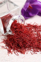 Dried saffron and crocus flower on white wooden table, closeup