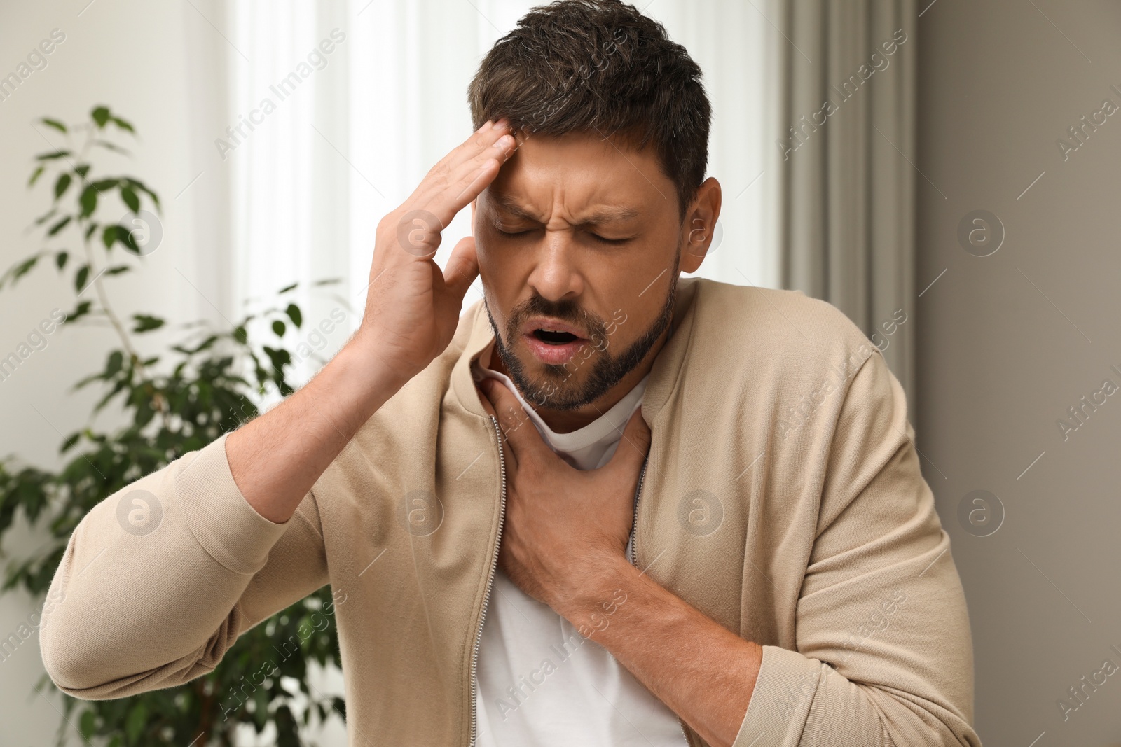 Photo of Man suffering from pain during breathing at home