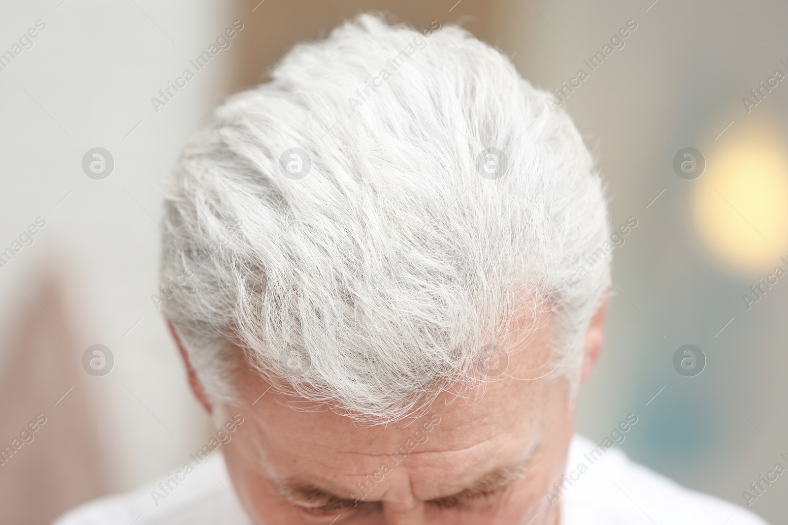 Photo of Senior man with hair loss problem indoors, closeup