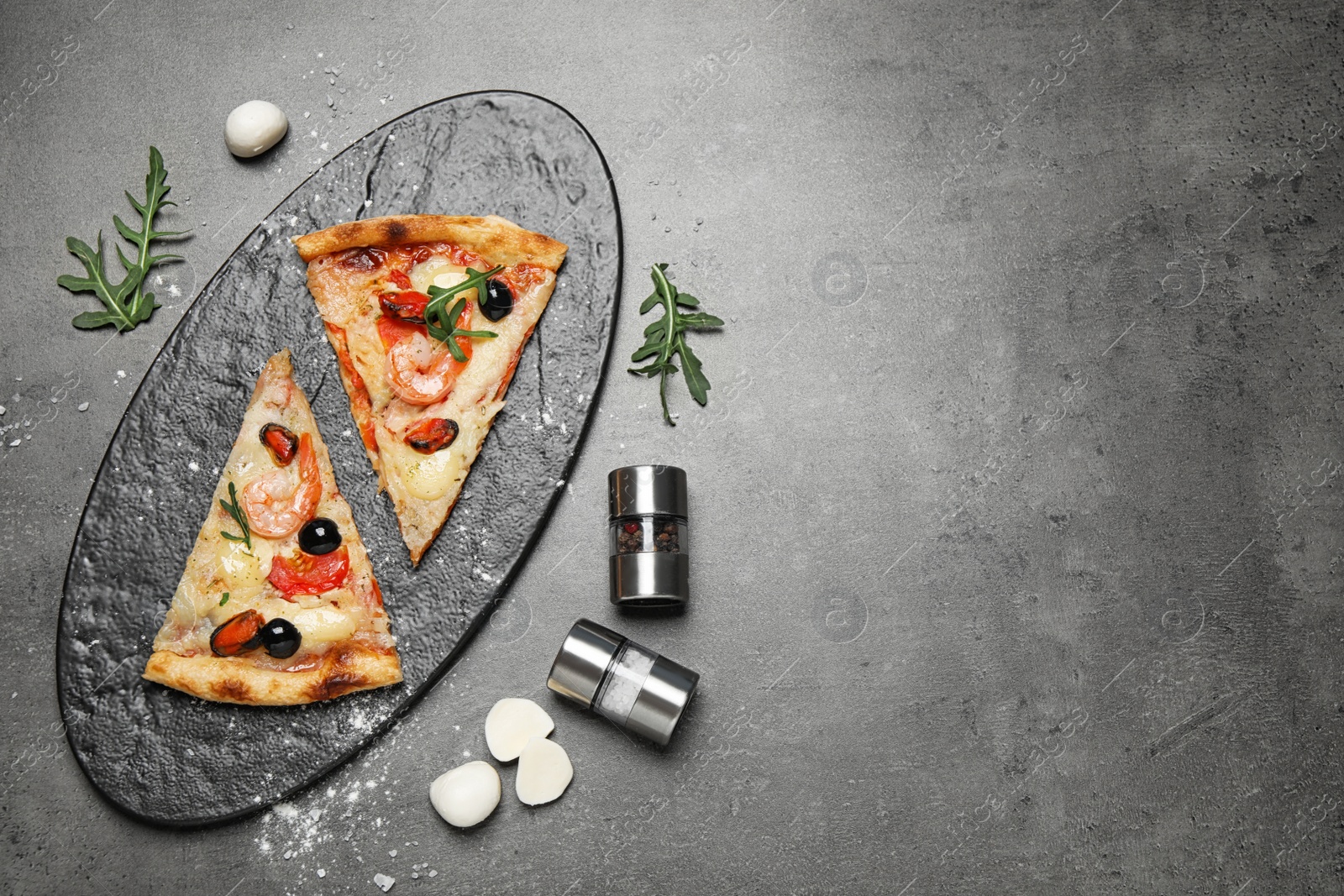 Photo of Tasty pizza with seafood and ingredients on grey table, flat lay. Space for text