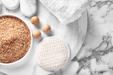 Photo of Flat lay composition with brown sea salt on marble background. Spa treatment