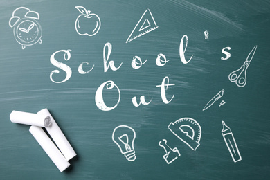 Image of Pieces of white chalk and text SCHOOL'S OUT written on greenboard, flat lay