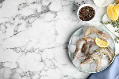 Photo of Flat lay composition with raw shrimps on marble table. Space for text