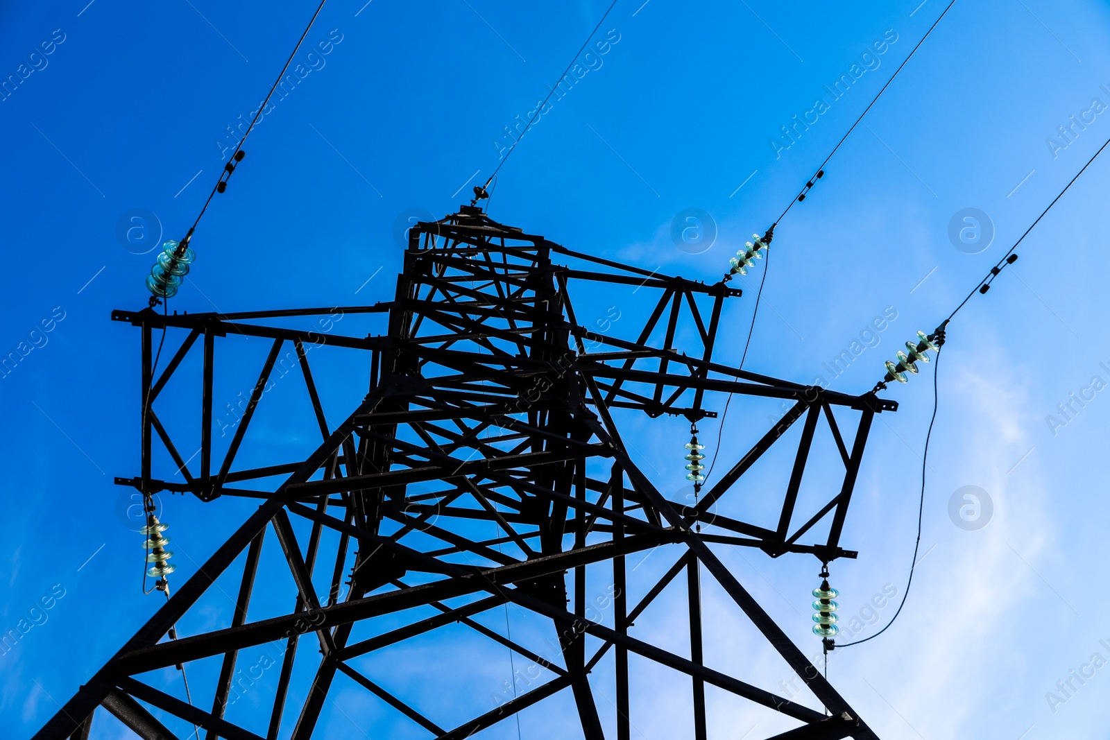 Photo of High voltage tower against beautiful blue sky, low angle view