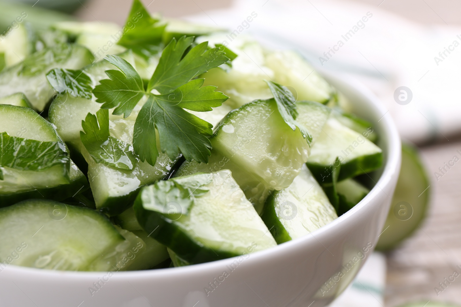 Photo of Delicious cucumber salad in bowl on table, closeup