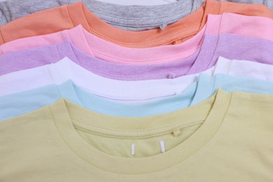 Photo of Many stacked clothes as background, top view