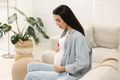 Photo of Pregnant young woman on sofa at home