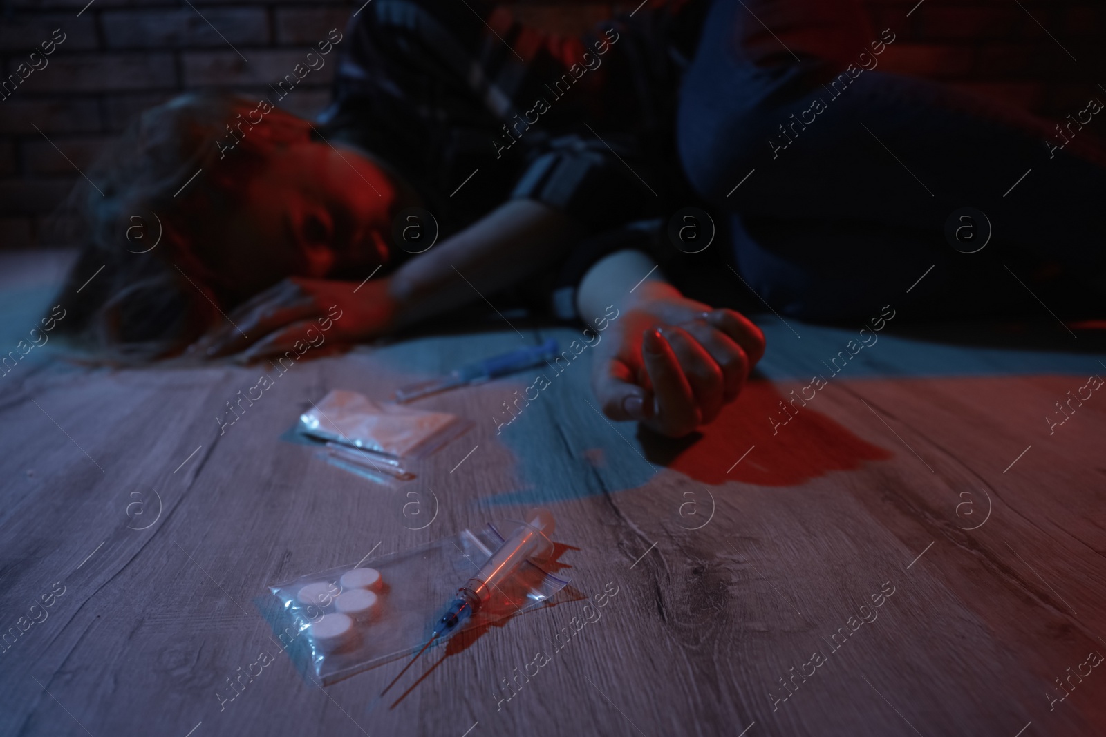 Photo of Addicted woman lying indoors, focus on different drugs