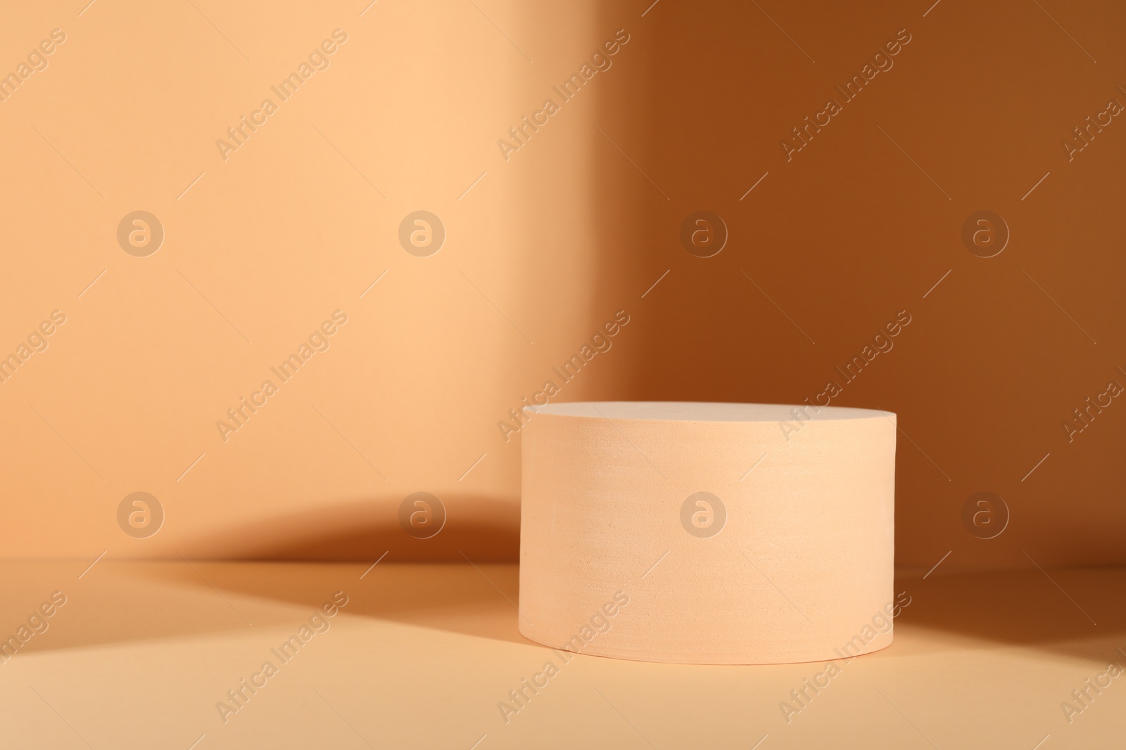 Photo of Presentation of product. Podium and shadows on orange background. Space for text