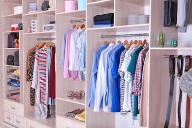 Photo of Large wardrobe with different clothes and shoes