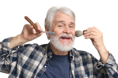 Photo of Senior man with mustache holding blade and brush on white background