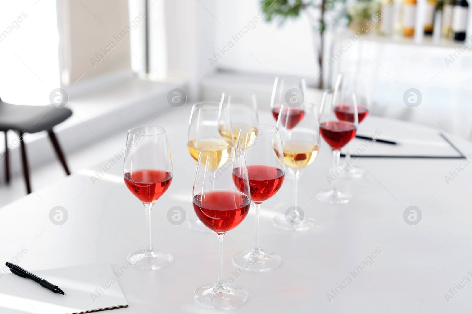 Photo of Glasses with delicious wine on table indoors