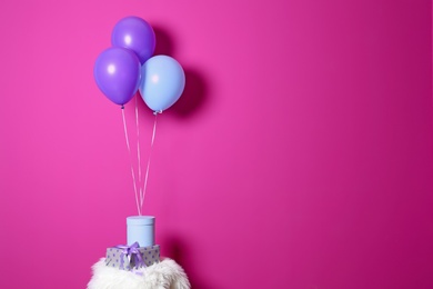 Gift boxes and balloons against color background