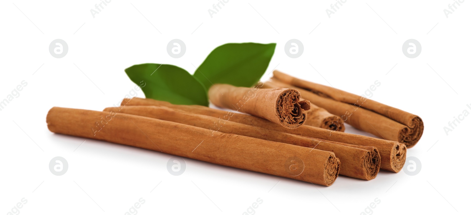 Photo of Aromatic dry cinnamon sticks and green leaves on white background